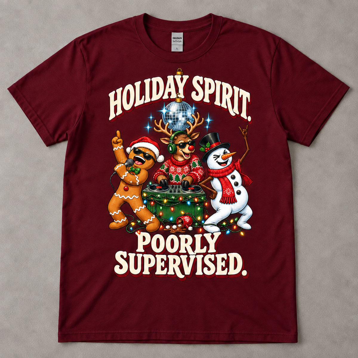 Maroon Gildan Softstyle G640 tee on a neutral gray table with Aurendae's Holiday Spirit. Poorly Supervised. Christmas party graphic.